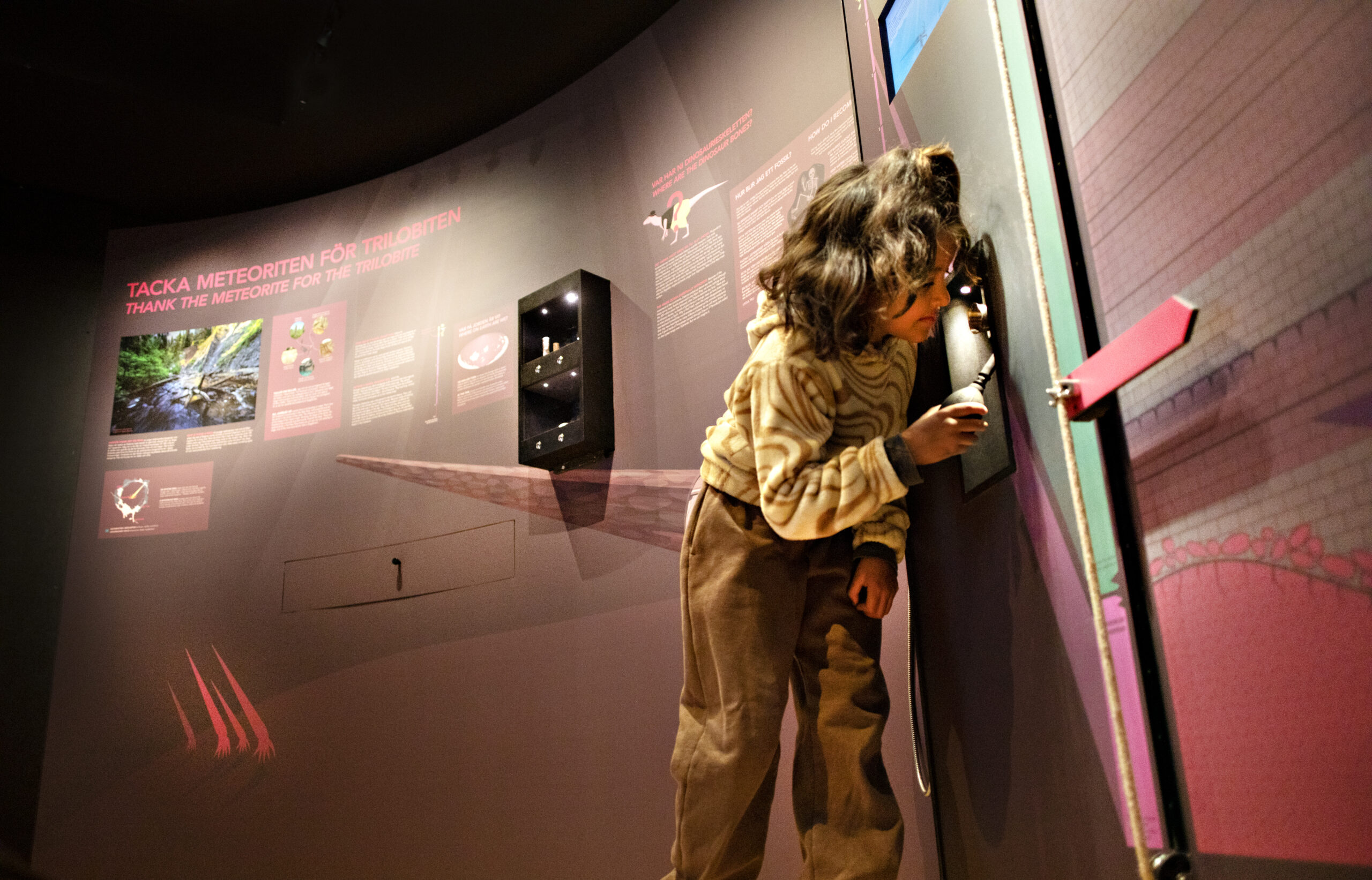 Flicka med mörkt hår interagerar med utställningen.